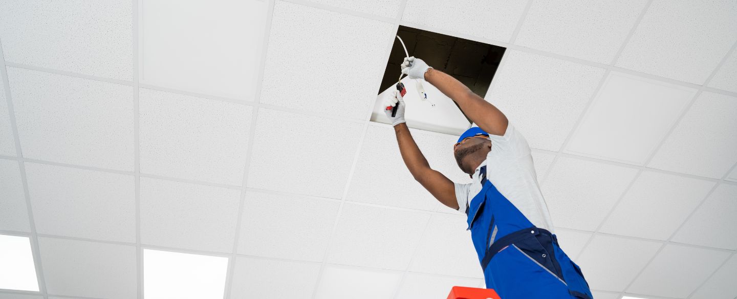 electrician on stepladder installing light on ceiling denver nc